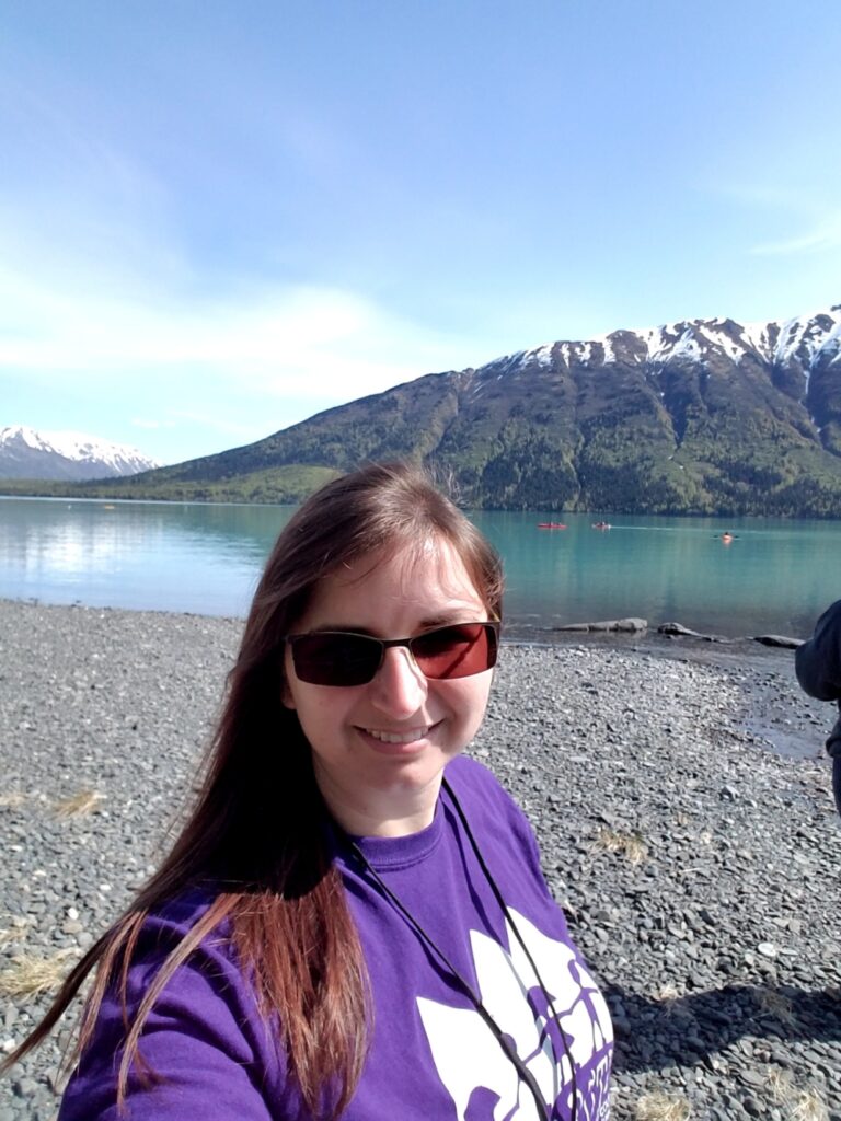 Image of Brandi standing by Kenai River with mountains in background